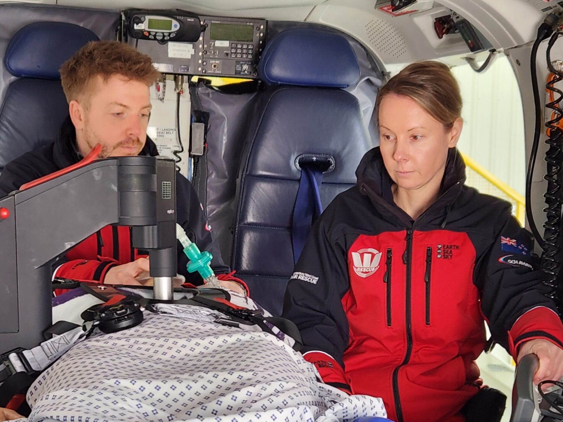 Scott Deakin and Kaz Walsh using MCPR and breathing bag on mannequin inside heli