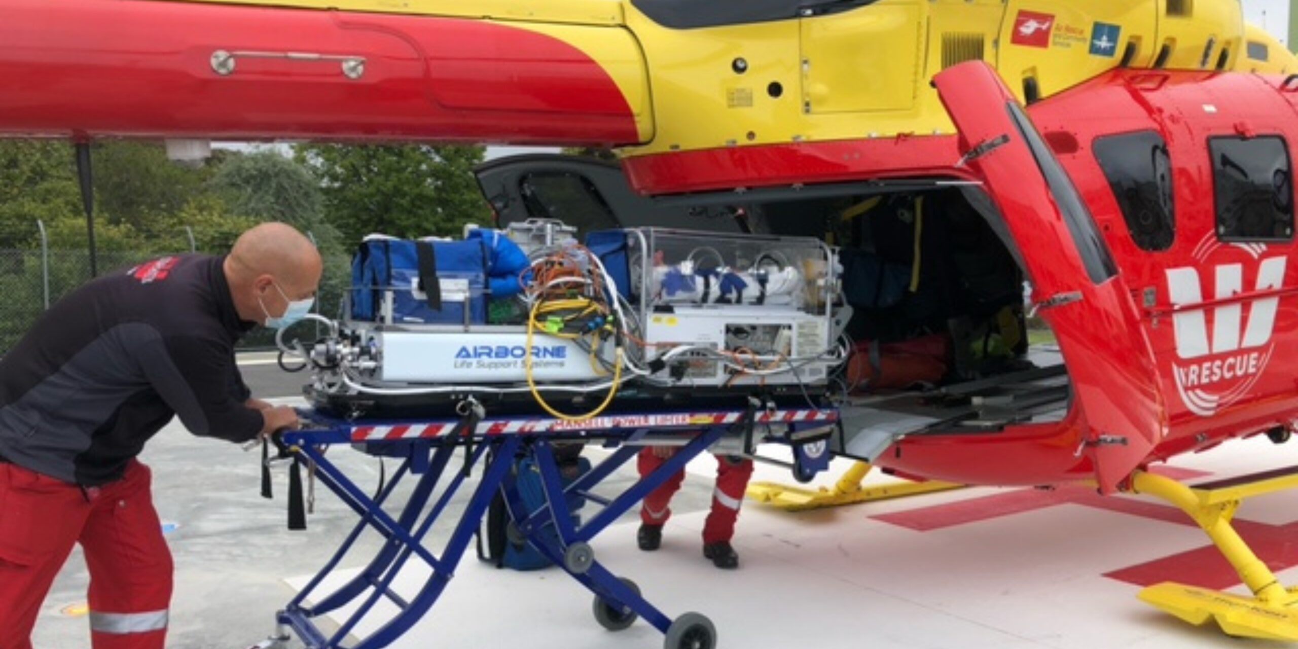 Paramedic Rob pushing a baby incubator into the back of the rescue helicopter