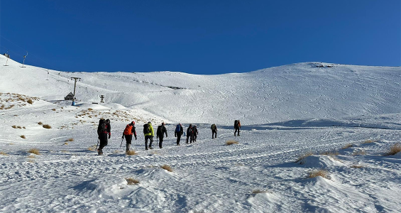 group hiking up a ski field
